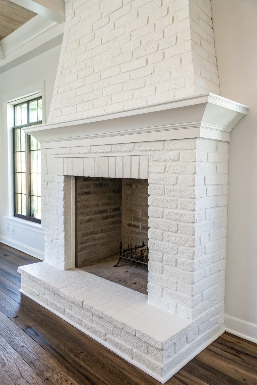 Minimalist white-on-white: a painted brick fireplace that expands space with effortless elegance.