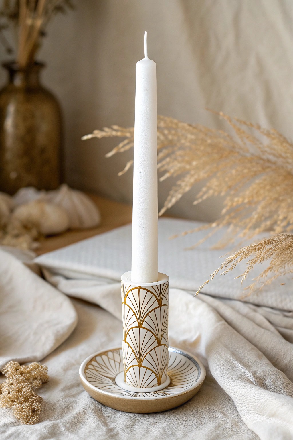 Elevate your table with Art Deco glam: hand-painted gold motifs on a simple white candle.