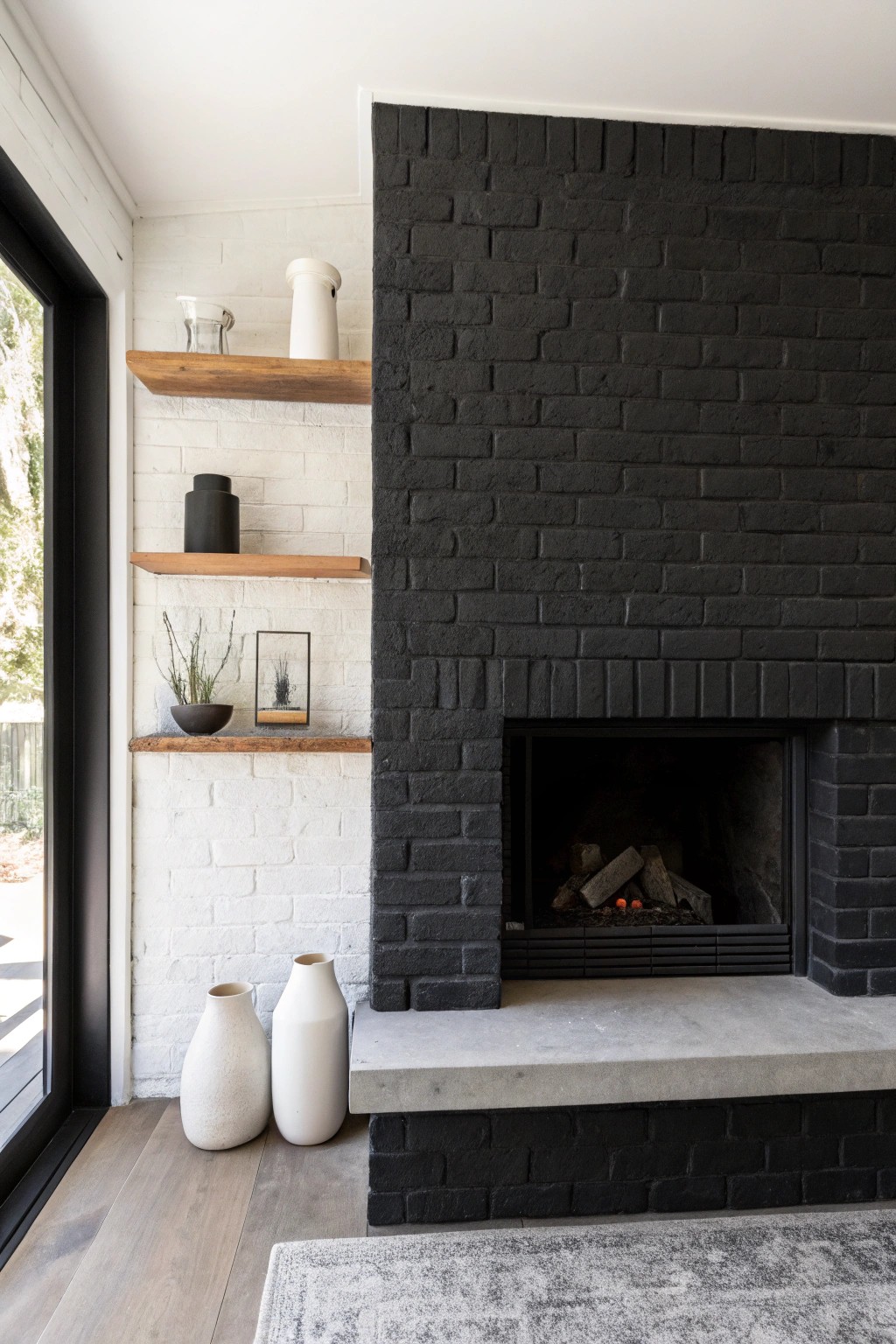 Elevate your space with a striking black brick fireplace and concrete accents—industrial chic at its finest.