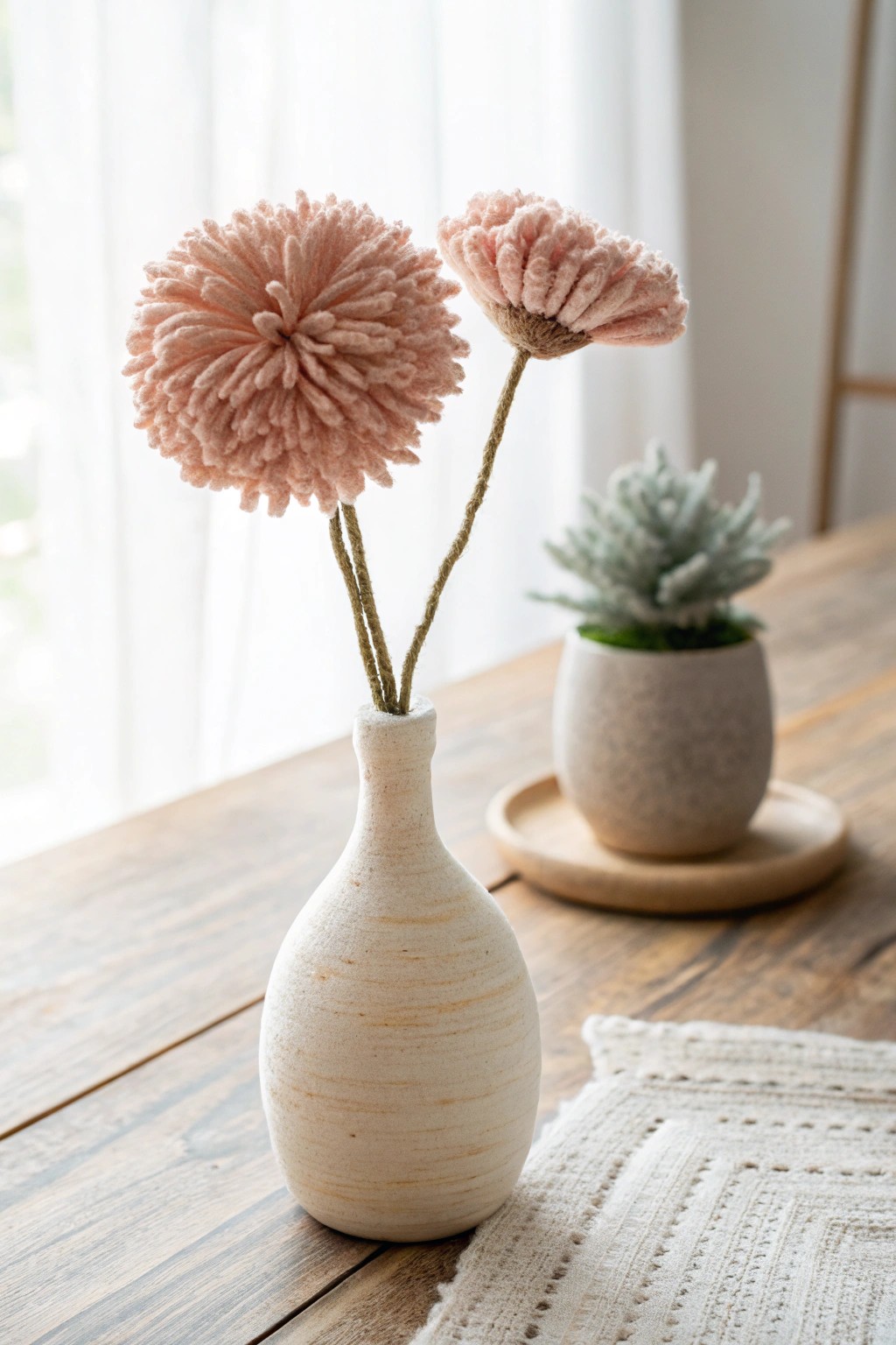 A single pom pom yarn flower in a crafted vase—simple beauty, everlasting joy.